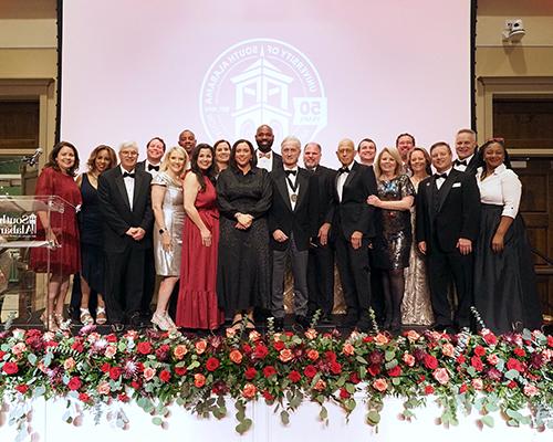 Distinguished Alumni Award recipients standing on stage.