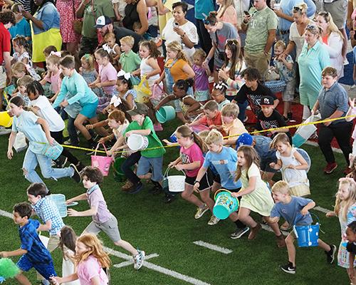 Kids running to start Alumni Easter Egg Hunt.