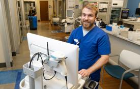 Luke Thomas, a University of South Alabama graduate, at his job at USA Health University Hospital 